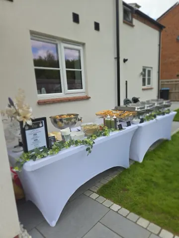 A dressed buffet run along a garden patio at a house.