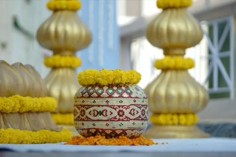 Marigold flowers and a gold kalash arranged as wedding decoration.
